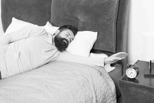 Early morning awakening hate noise of alarm clock Stages of sleep Man at home Health care concept need more relax in bed stressed and unhappy man bearded man hipster want to sleep