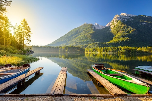 Early morning near the lake with boats and mountains beautiful\
sunny holiday recreation landscape