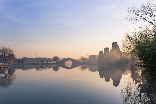 In the early morning of the park, there is mist on the water