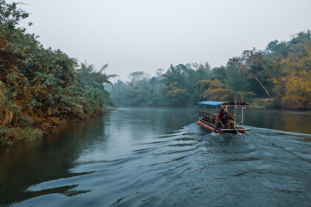 La mattina presto al fiume kwai in thailandia con il concetto turistico all'aperto di viaggio in zattera di legno