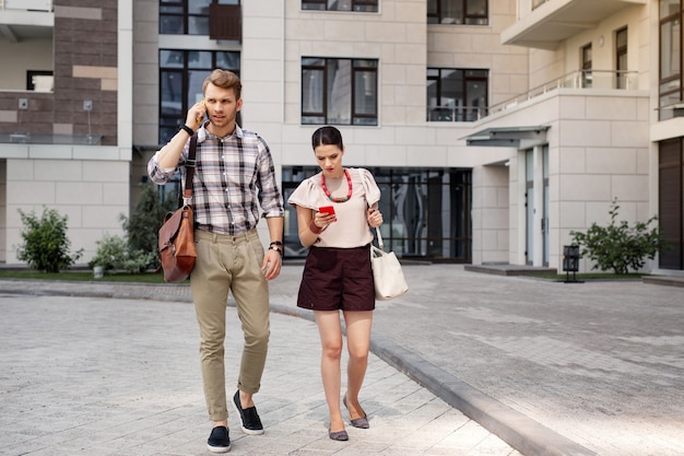 Early morning. Smart young people walking together while going to work