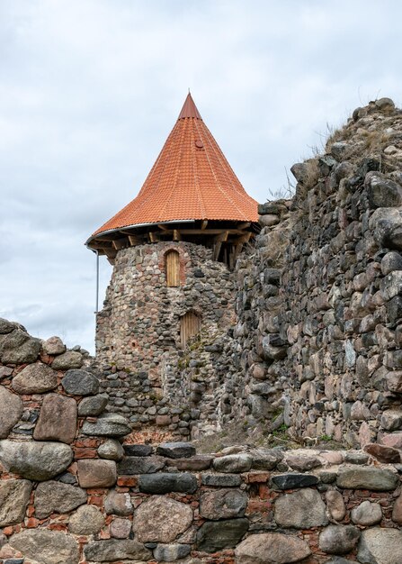 Early spring landscape with a view of the castle ruins the new bright orange roof of the castle tower stands out ergeme castle ruins valka district latvia