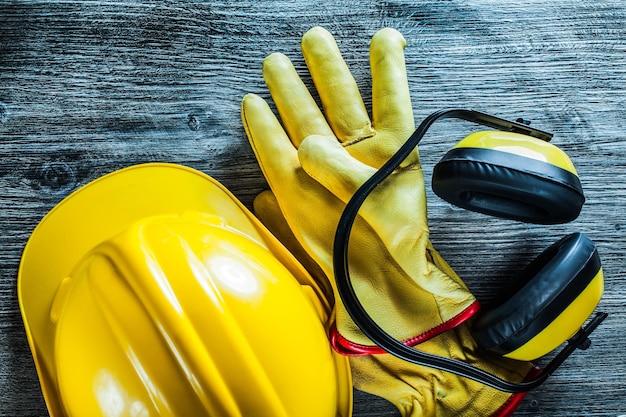 Foto guanti protettivi per cuffie da costruzione casco su tavola di legno