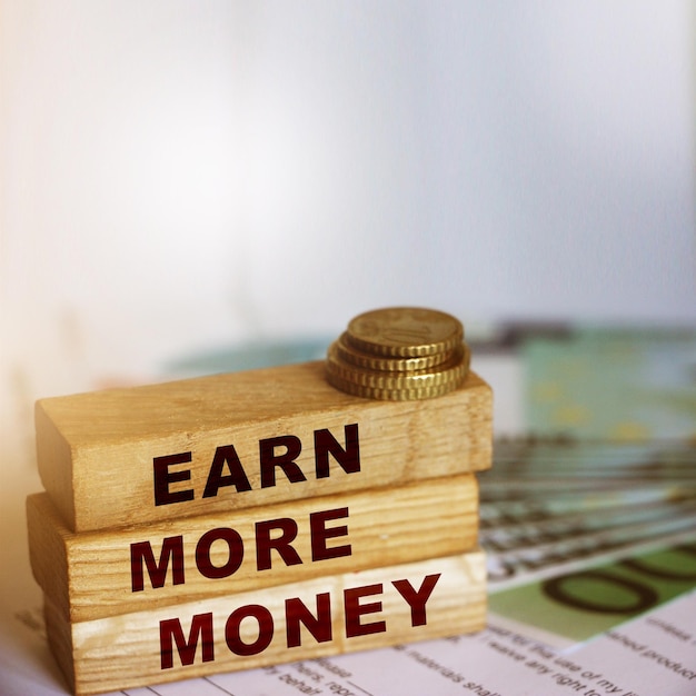 Earn More Money on wooden blocks coins and bills Business and career concept