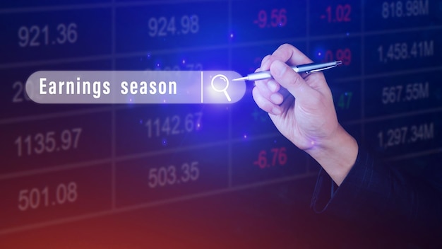 Earnings season Hand touching of written in search bar with the financial data visible in the background Reports Stock Market Ticker Words