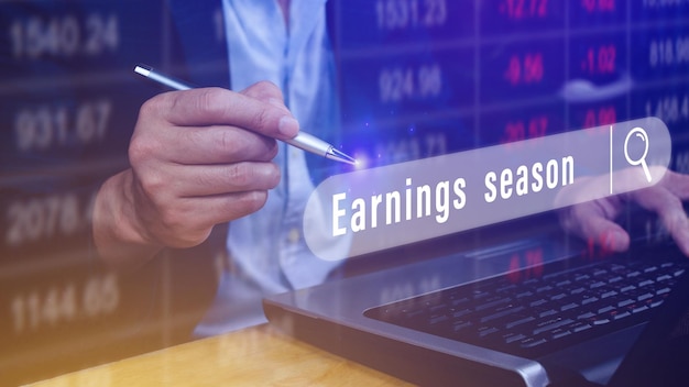 Earnings season Hand touching of written in search bar with the financial data visible in the background Reports Stock Market Ticker Words