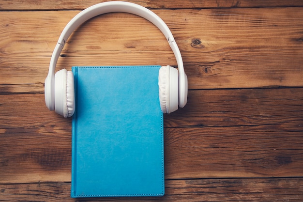 Earphone on book on the wooden table