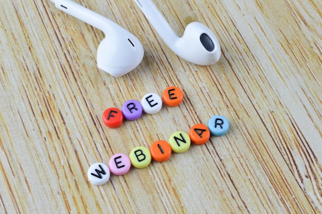 Earphones and alphabet beads with text FREE WEBINAR Business and education concept