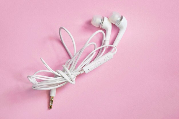 Earphones on pink background