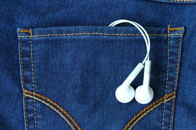 earphones on the vintage tone colored of back pocket of the jean