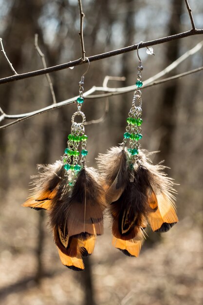 Photo earrings of handmade dream catcher with feathers threads and beads rope hanging