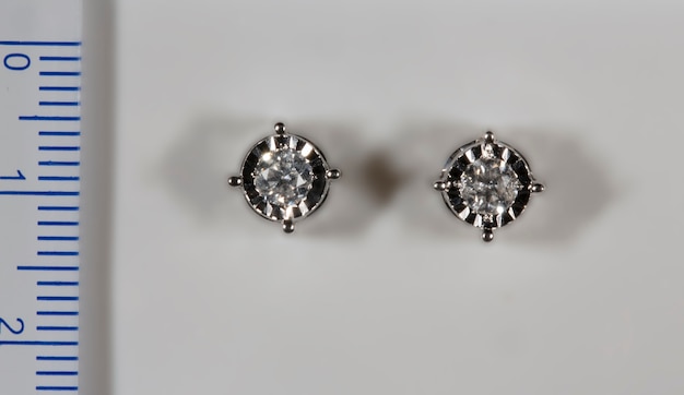 Earrings made of white gold with natural diamonds next to the ruler the diamonds in the center are  ...