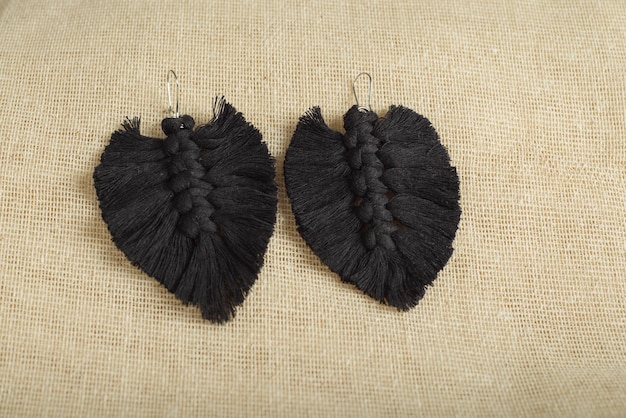 Earrings made with thread on a textile background Handmade earrings