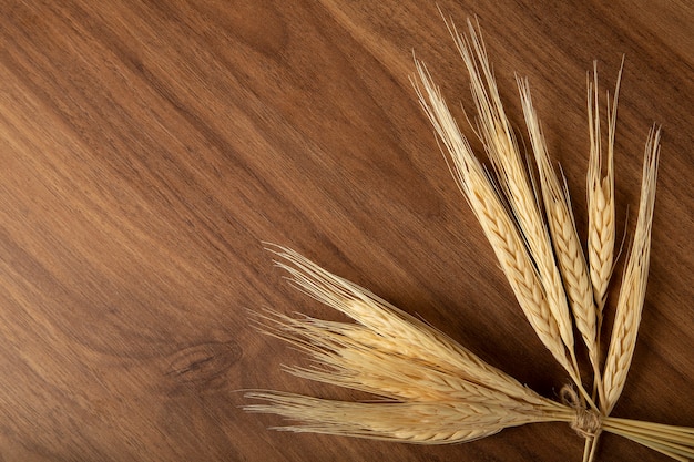 Photo ears of wheat on wooden background