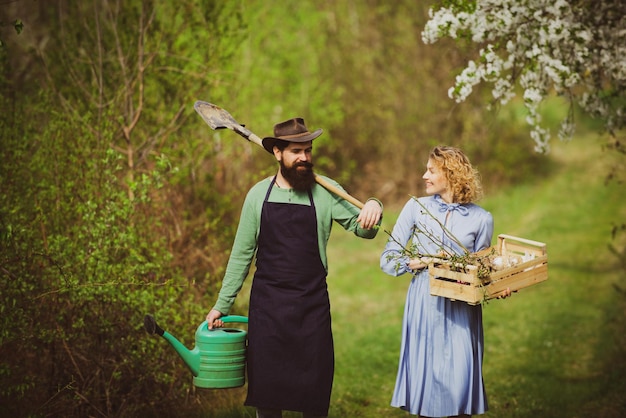 Earth concept afbeelding van twee gelukkige boeren met instrumenten een boer en zijn vrouw staan in hun fi...