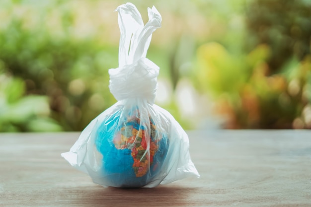 Earth day concept globe in plastic bag on table 