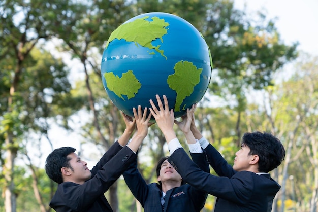 Earth day concept with big Earth globe held by group of asian business people team promoting environmental awareness to solve global warming with environmentally sustainability and ESG principle Gyre