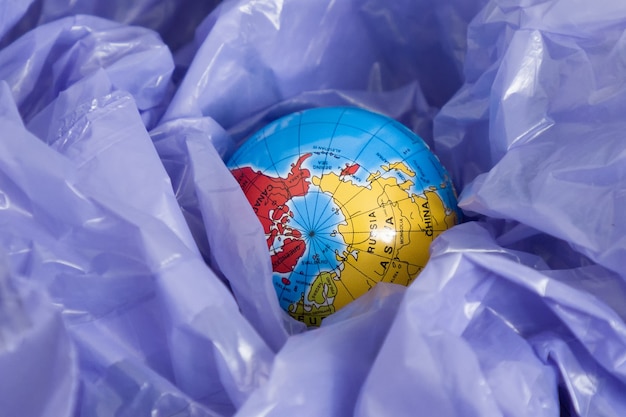 Foto la giornata della terra, un globo in un sacco della spazzatura