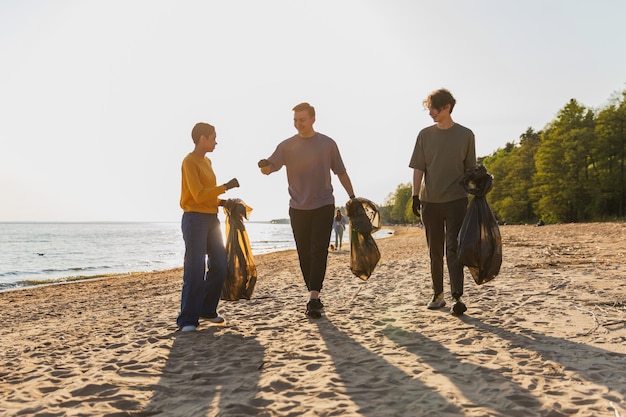 Earth day volunteers activists team collects garbage cleaning of beach coastal zone woman mans with