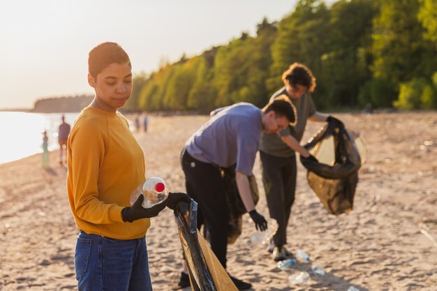 Earth Day vrijwilligers activisten team verzamelt vuilnis schoonmaak van het strand kustzone vrouw zet