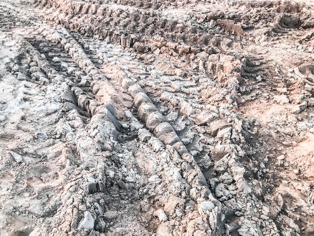 車の車輪の跡がついた土砂 泥の畝間 建設現場の大量の砂