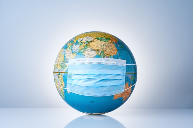 Photo earth globe with medical mask on