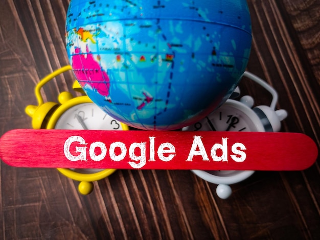 木製の背景にテキスト google 広告と地球の地球時計とアイス クリーム スティック