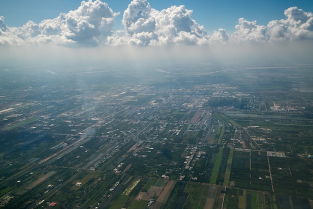 Earth landscape viewed from airplane. Earth surface under the white clouds from aerial view.