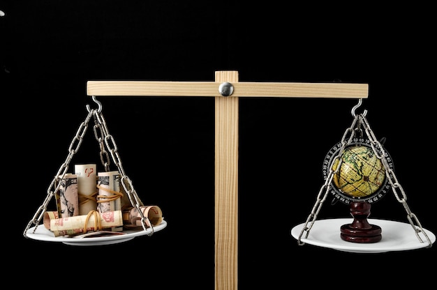 Photo earth and money on a two pan balance