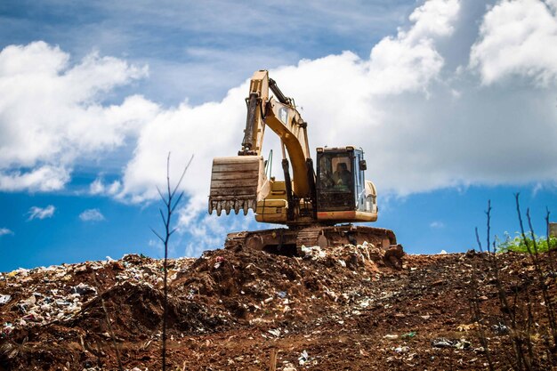 Photo earth mover on land against cloudy sky