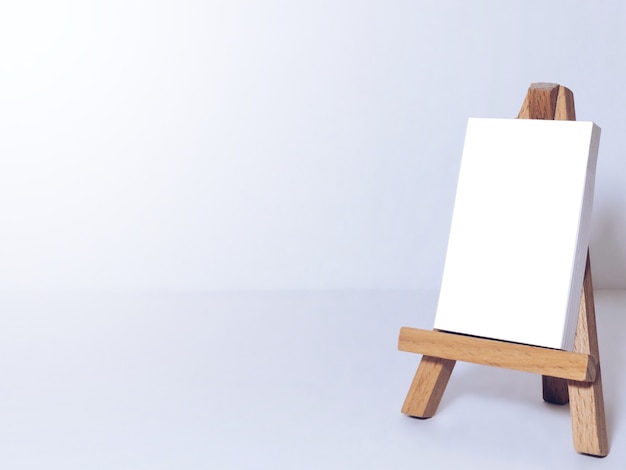 Easel for artists and blank canvas miniature on white background.