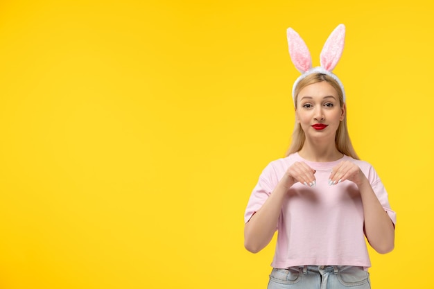 Easter adorable pretty young blonde girl with bunny ears pranking and making a bunny paw gesture