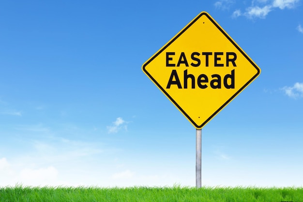 Easter ahead road sign against empty field and blue sky
