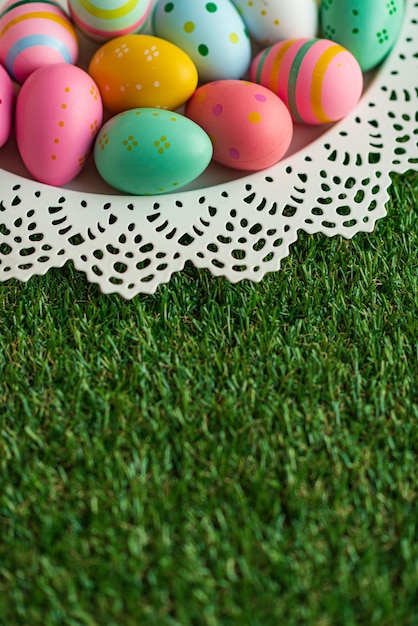 Easter background with colorful painted pink blue yellow Easter eggs and green grass Top view with copy space Easter holidays banner and header High quality photo