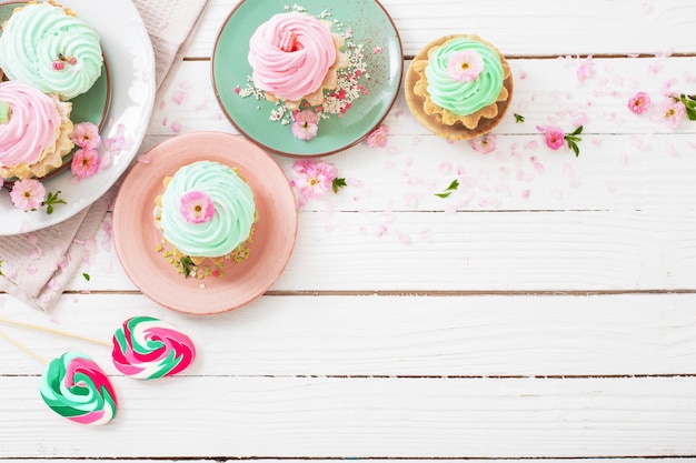 Easter background with cupcakes lollipops and spring flowers