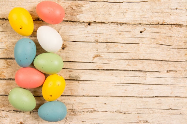 Easter background with handmade colored eggs on wooden table. Frame and copy space.