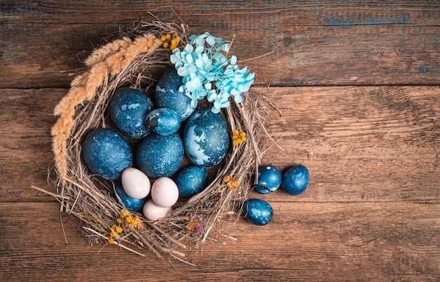 Easter background with quail and chicken blue eggs on wooden background.