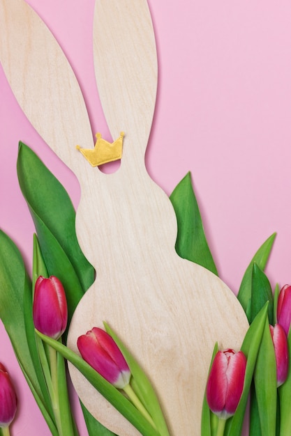 Easter banner with wooden bunny figure and purple fresh tulips. Copy space for text