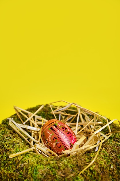 Photo easter basket nest with easter eggs on yellow background with copy space