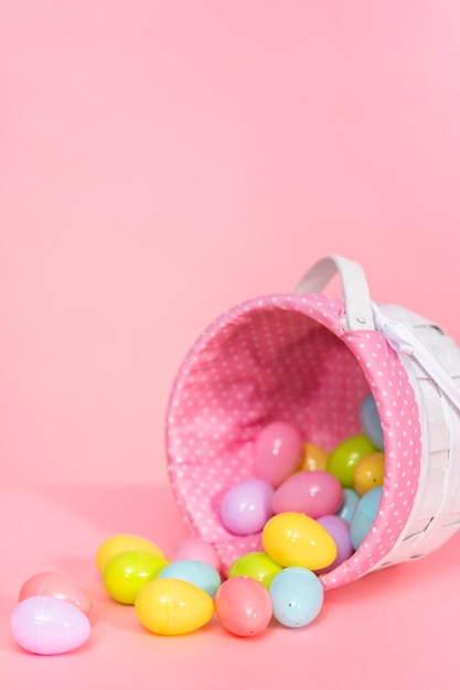 Easter basket with easter eggs on a pink background.