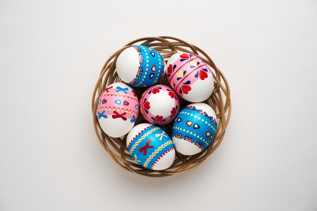 Photo easter basket with easter eggs on white background