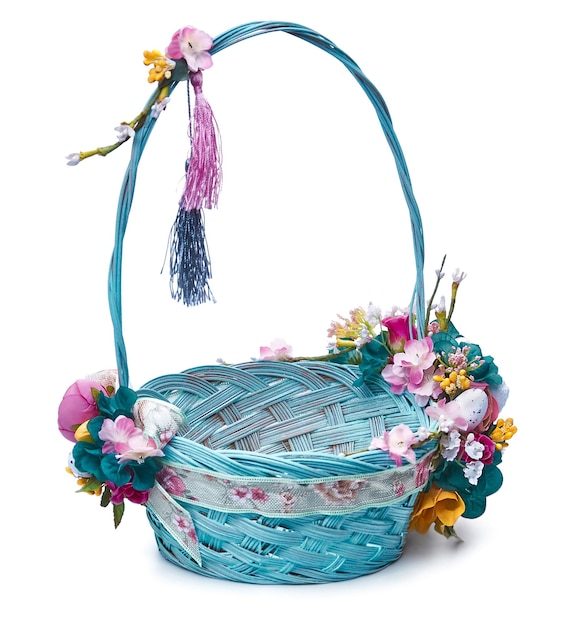 Easter basket with eggs and flower arrangement on a white background