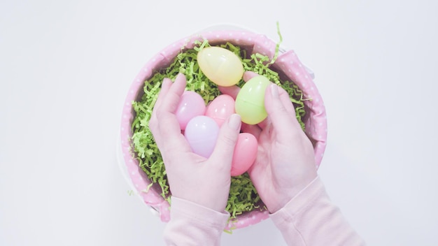 Cesto di pasqua con erba di carta verde su sfondo bianco.