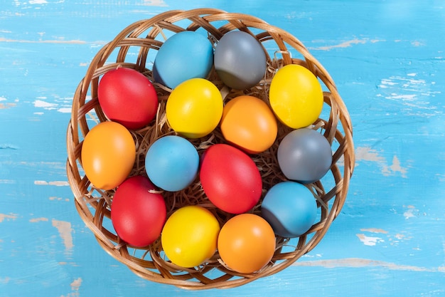 Easter basket with straw and colored eggs