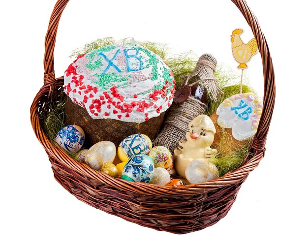 Easter basket with traditional easter cake kulich Ukrainian style with colored eggs and Kagor On white background