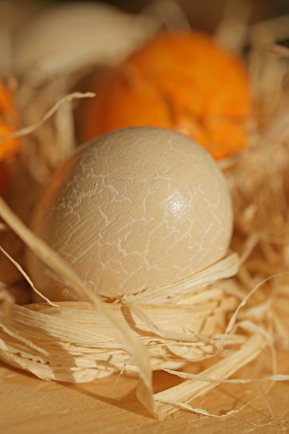 Easter. beige and orange Easter eggs in the straw on a wooden surface