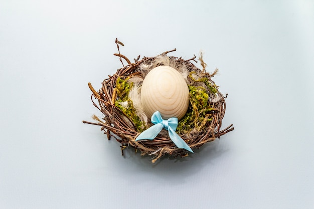 Easter bird nest. Zero waste, DIY concept. Soft feathers, moss. Light blue background