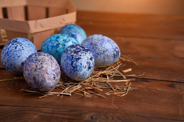 Easter blue eggs in basket on wooden background