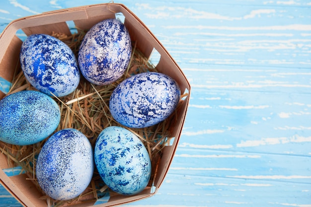 나무 테이블에 바구니에 부활절 블루 계란