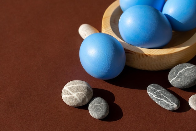 Easter blue eggs with sea pebbles on a brown background
